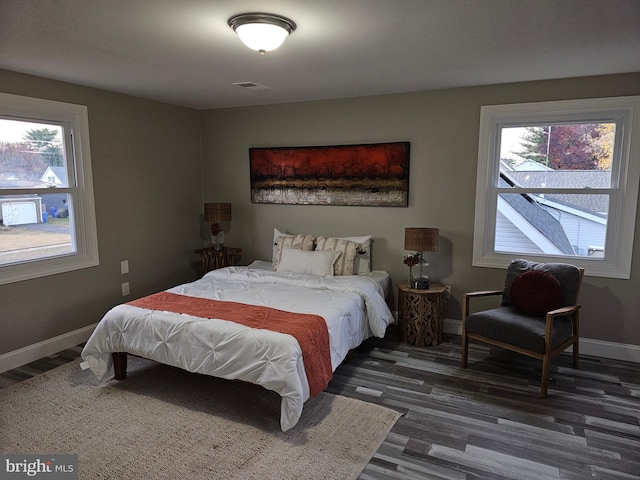 bedroom featuring dark wood-type flooring and multiple windows