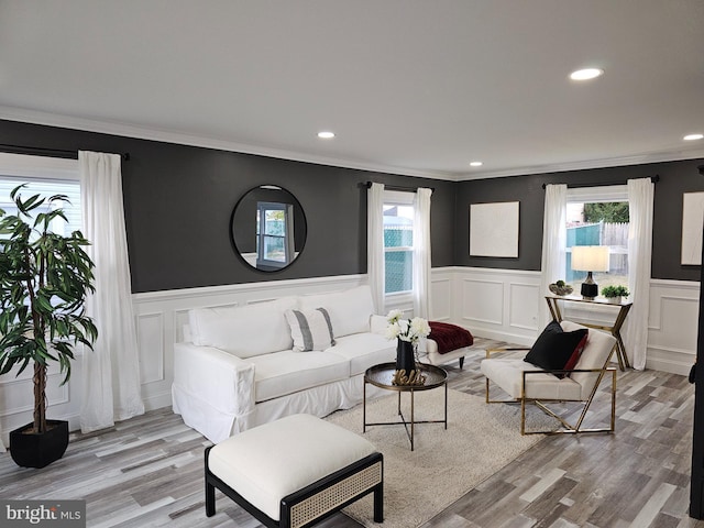 living room with plenty of natural light, crown molding, and light hardwood / wood-style flooring