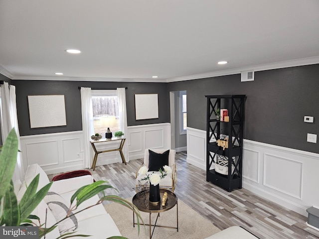 living room featuring light wood-type flooring and ornamental molding