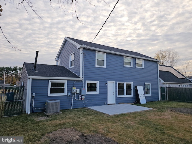 back of property with cooling unit, a yard, and a patio