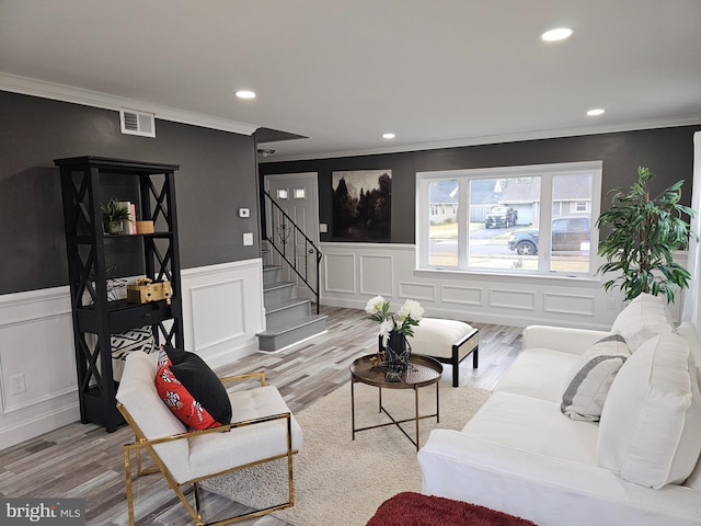 living room with light hardwood / wood-style floors and crown molding