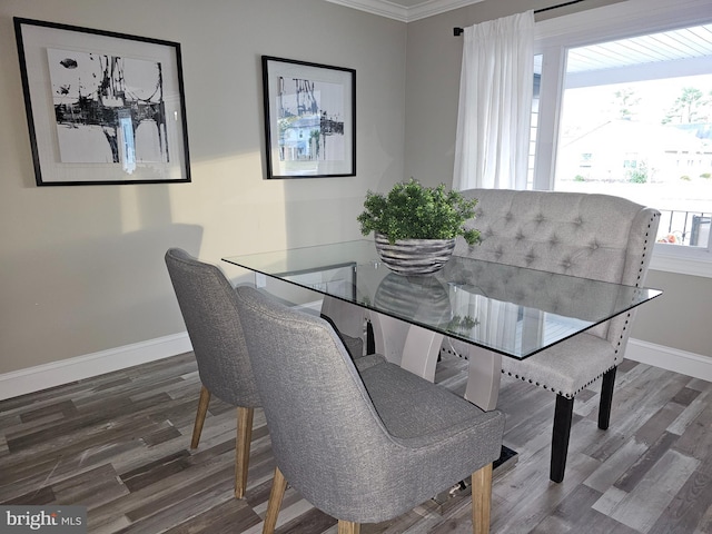 dining area with ornamental molding, plenty of natural light, and dark wood-type flooring