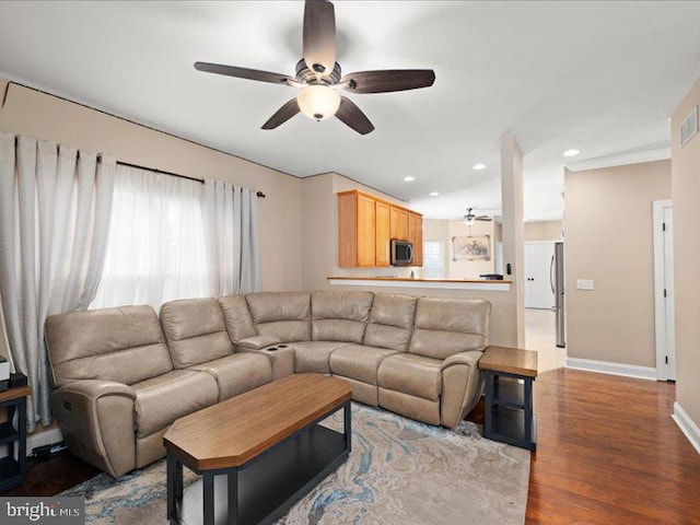 living room featuring hardwood / wood-style floors and ceiling fan