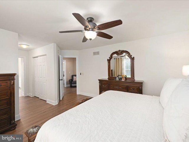 bedroom with ceiling fan, a closet, and dark hardwood / wood-style flooring