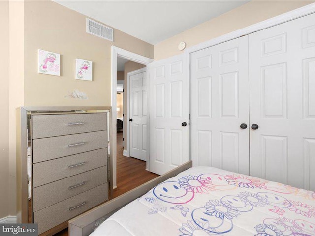 bedroom with a closet and dark hardwood / wood-style flooring