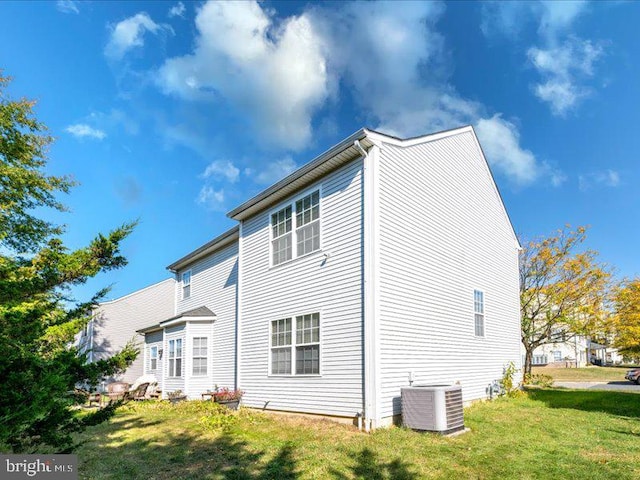 back of house featuring a yard and cooling unit