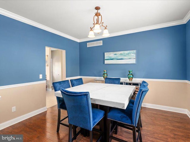 dining space featuring crown molding, dark hardwood / wood-style floors, and a notable chandelier