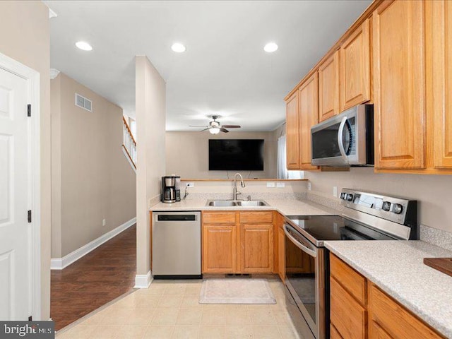 kitchen featuring appliances with stainless steel finishes, ceiling fan, sink, and light hardwood / wood-style floors