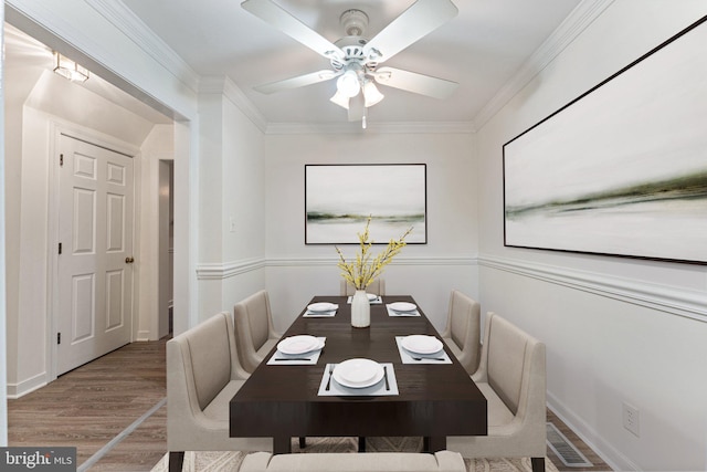 dining space with ornamental molding, hardwood / wood-style flooring, and ceiling fan