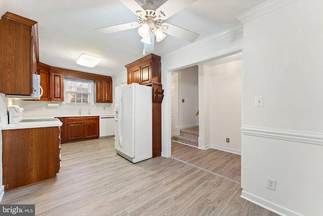 kitchen with white appliances, sink, ceiling fan, ornamental molding, and light hardwood / wood-style flooring