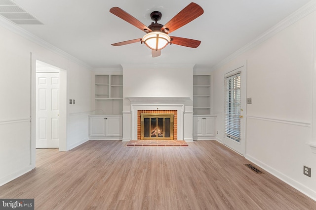 unfurnished living room featuring ceiling fan, built in features, light hardwood / wood-style flooring, and a fireplace