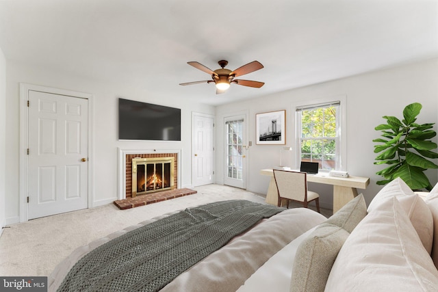 bedroom featuring ceiling fan, light carpet, and a brick fireplace