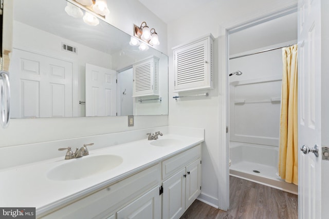 bathroom with vanity, walk in shower, and wood-type flooring