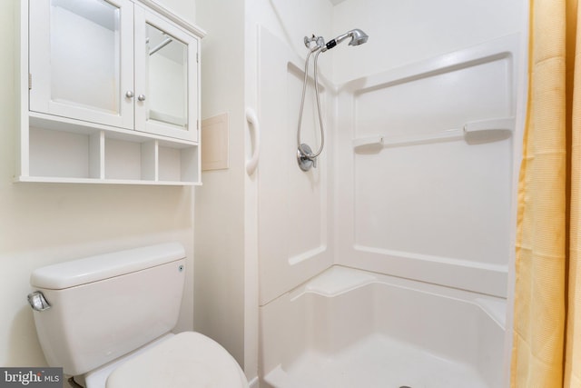 bathroom featuring a shower with shower curtain and toilet