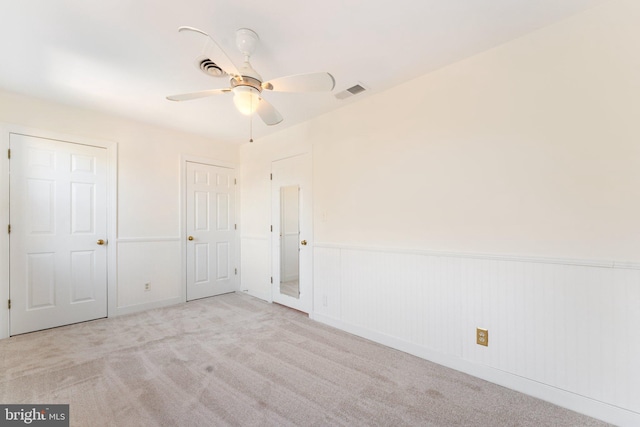 unfurnished bedroom featuring light carpet and ceiling fan