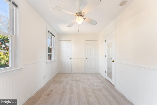 carpeted spare room with ceiling fan