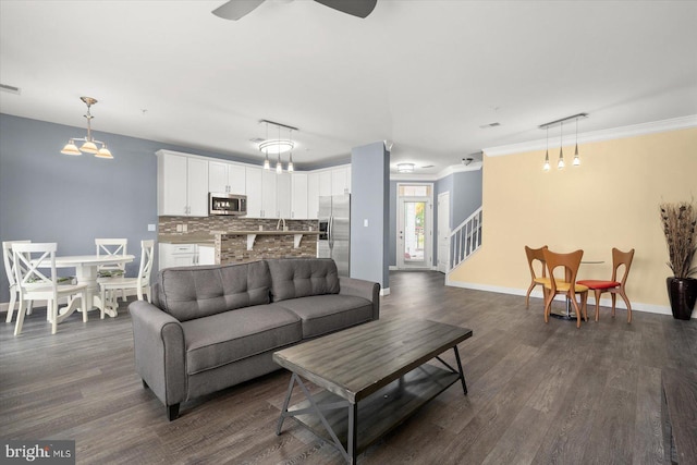 living room with crown molding, ceiling fan, and dark hardwood / wood-style flooring