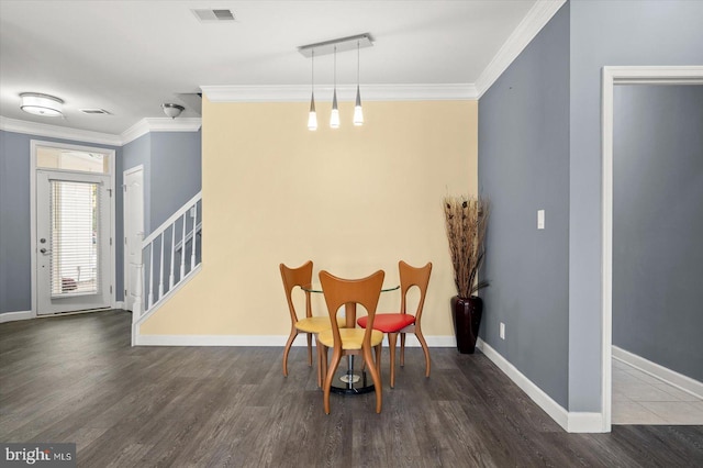 dining room with ornamental molding and dark hardwood / wood-style flooring