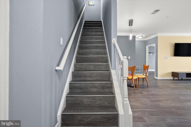 stairs featuring ornamental molding and hardwood / wood-style flooring