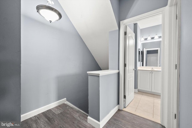 hallway with lofted ceiling and wood-type flooring