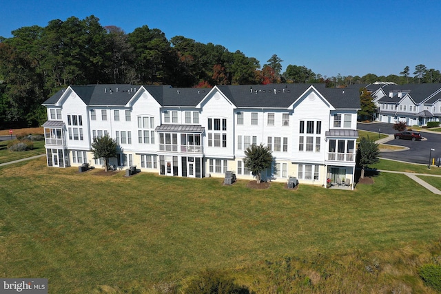 back of property with a yard and a balcony