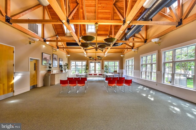 unfurnished dining area featuring beam ceiling, high vaulted ceiling, carpet, and wooden ceiling