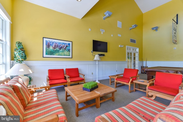 carpeted living room featuring high vaulted ceiling