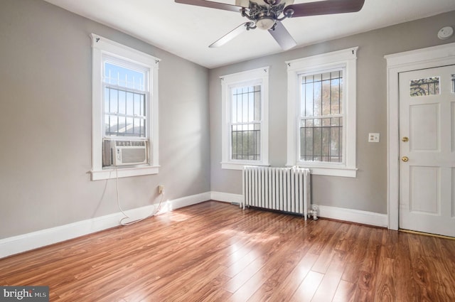 entryway with ceiling fan, a healthy amount of sunlight, radiator heating unit, and hardwood / wood-style floors