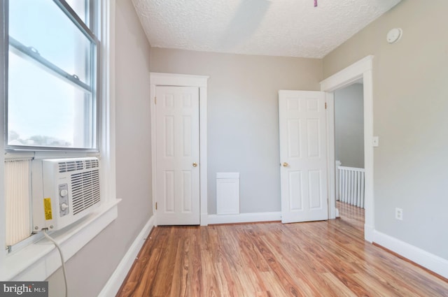 unfurnished bedroom with light hardwood / wood-style flooring and a textured ceiling