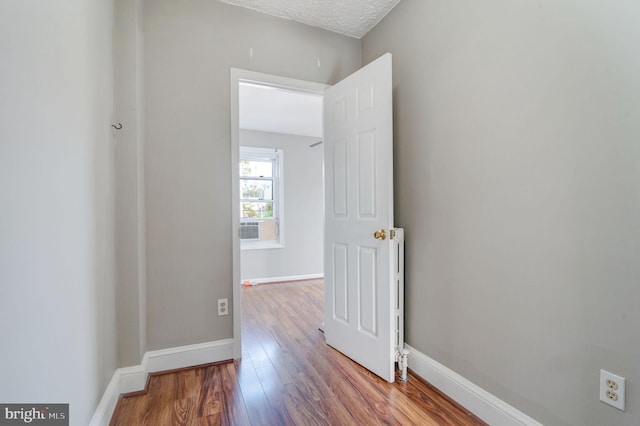 spare room with a textured ceiling and light wood-type flooring