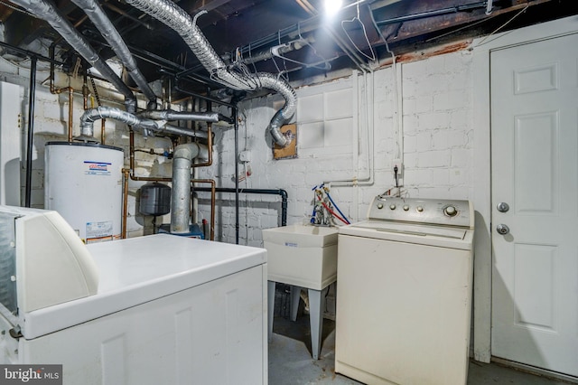 clothes washing area with independent washer and dryer, water heater, and sink