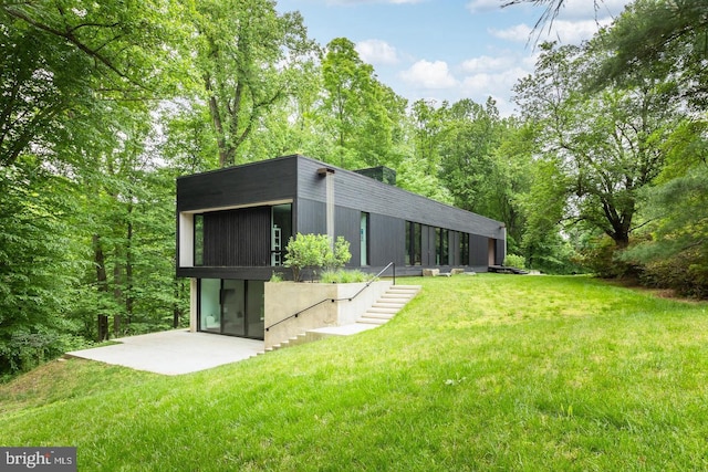 back of property featuring a patio and a lawn