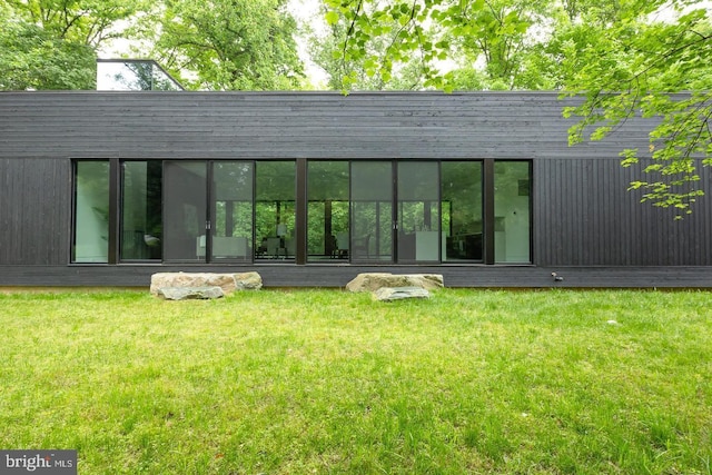 rear view of property with a lawn