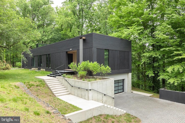view of front facade featuring decorative driveway, a front lawn, and a garage