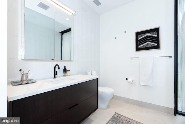 bathroom featuring toilet, vanity, and tile patterned flooring