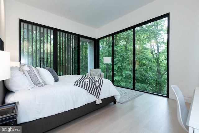 bedroom with hardwood / wood-style flooring and multiple windows