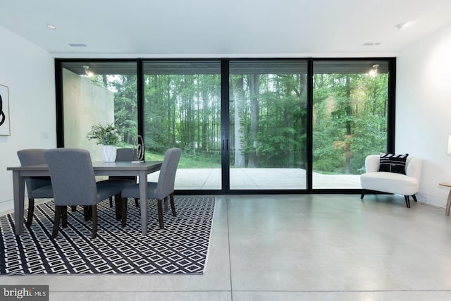 doorway featuring plenty of natural light, a wall of windows, and concrete flooring