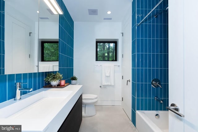 full bathroom with vanity, toilet, and tiled shower / bath