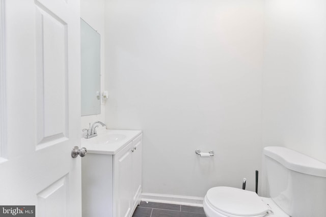 bathroom with toilet, vanity, and tile patterned floors