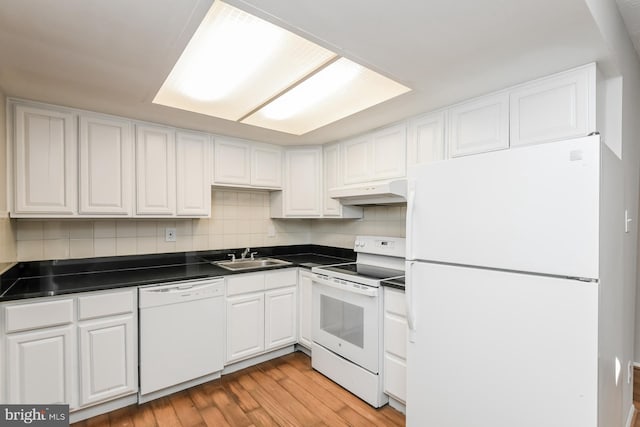 kitchen with white appliances, tasteful backsplash, white cabinetry, light hardwood / wood-style floors, and custom range hood