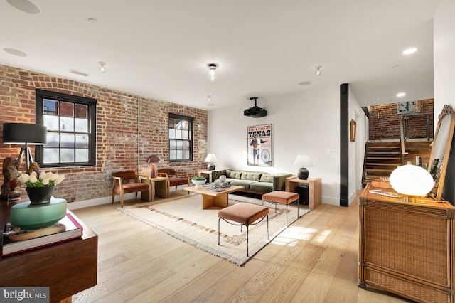 living room with brick wall and light wood-type flooring