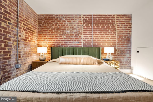 unfurnished bedroom featuring brick wall