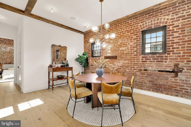 dining space featuring brick wall and light hardwood / wood-style flooring