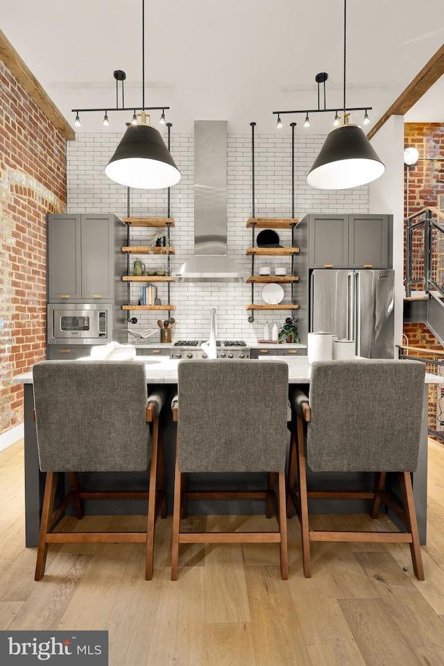 dining room featuring brick wall and light hardwood / wood-style flooring