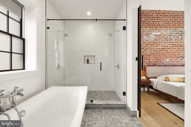 bathroom featuring hardwood / wood-style flooring and plus walk in shower