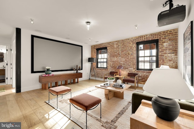 cinema featuring light hardwood / wood-style flooring and brick wall