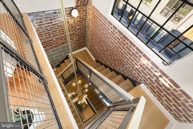 staircase with a high ceiling and brick wall