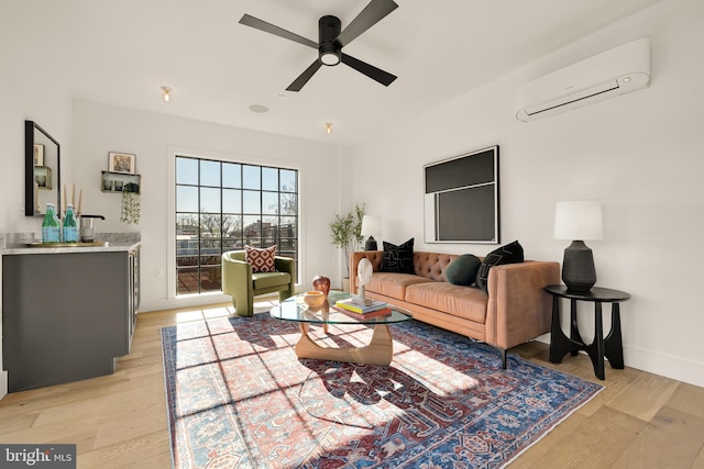 living room featuring light wood-type flooring, ceiling fan, and a wall mounted AC