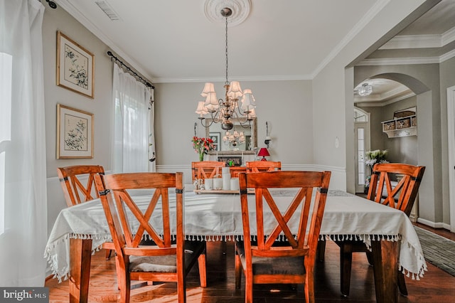 dining room featuring an inviting chandelier, wood-type flooring, and ornamental molding