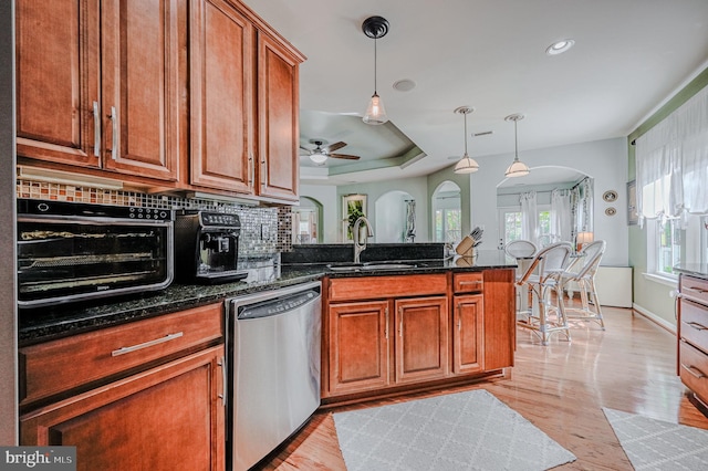 kitchen featuring tasteful backsplash, sink, dishwasher, dark stone countertops, and ceiling fan